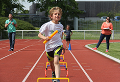 Jeune garçons en course relais sur la piste d'athlétisme